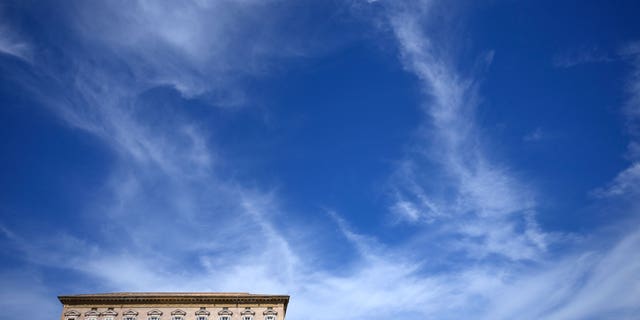 Pope Francis (second window from right) reads a message during Angelus' Noon Prayer from the window of his studio overlooking St. Peter's Square in the Vatican on Sunday, October 2, 2022. 