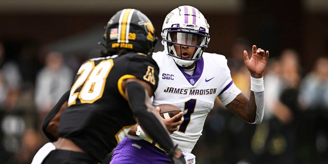 Todd Centeio (1) of the James Madison Dukes evades KeSean Brown (28) of the Appalachian State Mountaineers in the first quarter at Kidd Brewer Stadium Sept. 24, 2022, in Boone, N.C.
