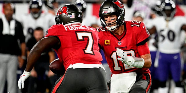 Tampa Bay Buccaneers quarterback Tom Brady (12) hands off to running back Leonard Fournette (7) during the first half of an NFL football game against the Baltimore Ravens Thursday, Oct. 27, 2022, in Tampa, Fla. 