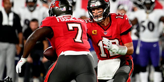 Tampa Bay Buccaneers quarterback Tom Brady (12) hands off to running back Leonard Fournette (7) during the first half of an NFL football game against the Baltimore Ravens Thursday, Oct. 27, 2022, in Tampa, Fla.