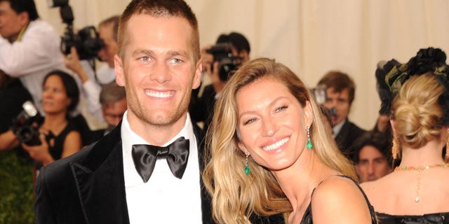 Tom Brady e Gisele sorriem para uma foto.