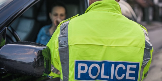 Traffic police officer talking to a woman in her car