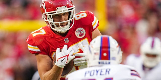 Kansas City Chiefs tight end Travis Kelce, #87, catches a pass as Buffalo Bills safety Jordan Poyer, #21, defends during the second half at GEHA Field at Arrowhead Stadium in Kansas City, Missouri, Oct. 16, 2022.