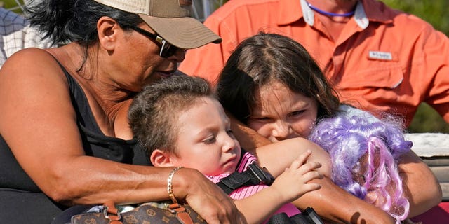 FILE - Yolanda Rios, left, holds her grandchildren Ava, 7, and Giovanni, 5, as as they are evacuated by airboat through floodwaters along the Peace River, to get to a hospital for medical care, in the aftermath of Hurricane Ian on Arcadia, Fla., Monday, Oct. 3, 2022. The devastation from Hurricane Ian has left schools shuttered indefinitely in parts of Florida, leaving storm-weary families anxious for word on when and how children can get back to classrooms. (AP Photo/Gerald Herbert, File)