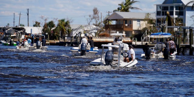 FILE - Boats operated by resident good Samaritans help evacuate residents who stayed behind on Pine Island, in the aftermath of Hurricane Ian in Matlacha Fla., Sunday, Oct. 2, 2022. The only bridge to the island is heavily damaged so it can only be reached by boat or air. The devastation from Hurricane Ian has left schools shuttered indefinitely in parts of Florida, leaving storm-weary families anxious for word on when and how children can get back to classrooms. (AP Photo/Gerald Herbert, File)