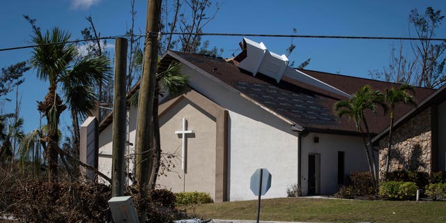 The steeple lays on its side atop Southwest Baptist Church in Fort Myers, Fla., on Sunday, Oct. 2, 2022. The church sustained heavy wind and flooding damage during Hurricane Ian as parishioners took refuge in the sanctuary. (AP Photo/Robert Bumsted)