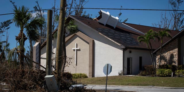 The steeple lays on its side atop Southwest Baptist Church in Fort Myers, Fla., on Sunday, Oct. 2, 2022. The church sustained heavy wind and flooding damage during Hurricane Ian as parishioners took refuge in the sanctuary. (AP Photo/Robert Bumsted)