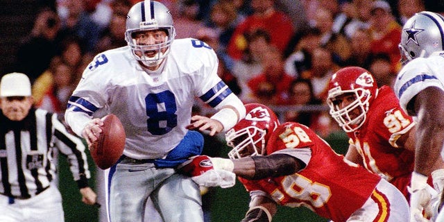 Dallas Cowboys' quarterback Troy Aikman about to be sacked by Kansas City Chiefs' linebacker Derrick Thomas (R) in Kansas City.