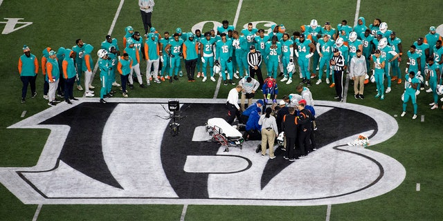 Teammates gather around Miami Dolphins quarterback Tua Tagovailoa after an injury during the first half of a game against the Cincinnati Bengals on September 29, 2022 in Cincinnati. 