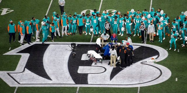 Teammates gather around Miami Dolphins quarterback Tua Tagovailoa after an injury during the first half of a game against the Cincinnati Bengals on September 29, 2022 in Cincinnati. 