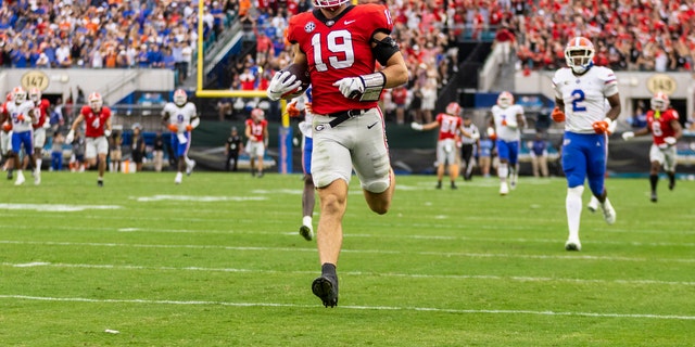 Georgia Bulldogs' Brock Bowers (19) catches a pass and runs into the end zone for a touchdown during the first half of a game against the Florida Gators at TIAA Bank Field on October 29, 2022 in Jacksonville, Florida.
