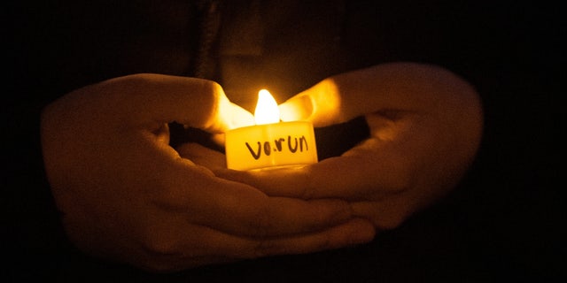A student, name not given, holds a candle during a vigil for Varun Manish Chheda, Wednesday, Oct. 5, 2022, at Purdue University in West Lafayette, Indiana.  Varun Manish Chheda, a Purdue student, was killed inside McCutcheon Hall early.  Wednesday.