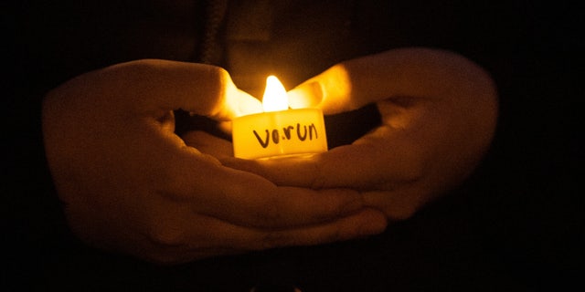 A student, name not given, holds a candle during a vigil for Varun Manish Chheda, Wednesday, Oct. 5, 2022, at Purdue University in West Lafayette, Ind. Varun Manish Chheda, a student at Purdue, was killed inside McCutcheon Hall early Wednesday.