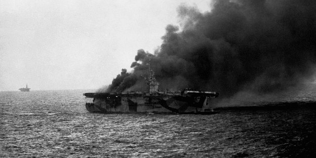 USS St Lo (CVE-63) burns after it's hit by Japanese suicide plane, Leyte Gulf, Phillipines. Close observation shows men going over the side. Oct. 25, 1944.