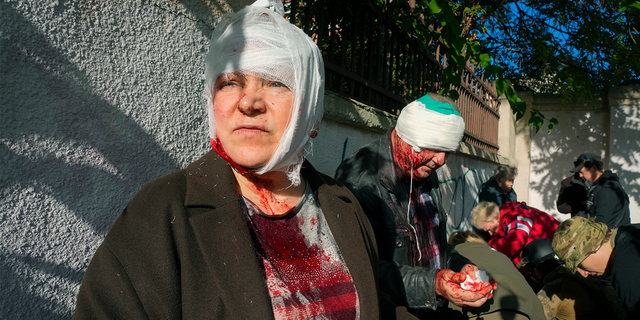 People receive medical treatment at the scene of Russian shelling, in Kyiv, Ukraine, Monday, Oct. 10, 2022.