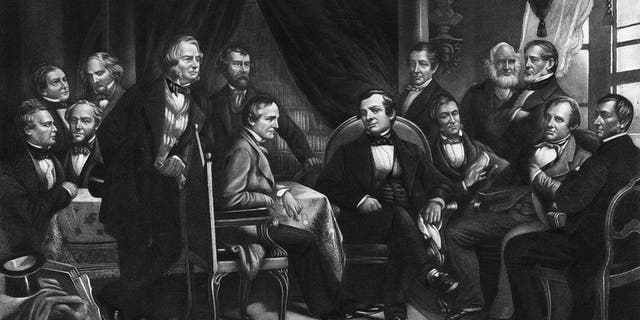 American author, biographer, historian and diplomat Washington Irving (center, sitting in black suit) with literary friends, circa 1830. From an original engraving by Geo. E. Perine. 