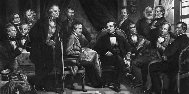 American author, biographer, historian and diplomat Washington Irving (center, sitting in black suit) with literary friends, circa 1830. From an original engraving by Geo. E. Perine. 