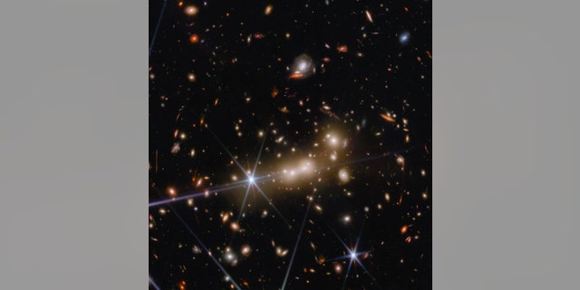The massive gravity of galaxy cluster MACS0647 acts as a cosmic lens