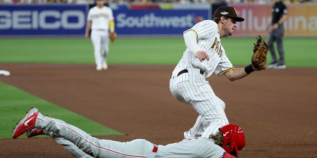 Wil Myers of the San Diego Padres, standing, tags first base before Bryson Stott of the Philadelphia Phillies slides in during the fifth inning of Game 1 of the National League Championship Series at PETCO Park Oct. 18, 2022, in San Diego.