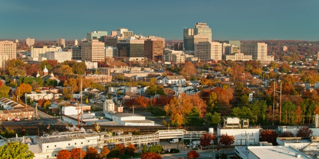 Aerial shot of Wilmington, Delaware, over the Christina River, looking across streets of row houses toward downtown office buildings.