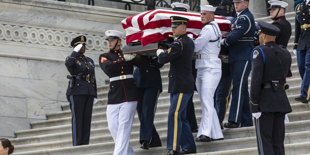 An honor guard carries the casket of Woody Williams down the U.S. Capitol steps after he lied in honor in Washington, D.C., on July 14, 2022.