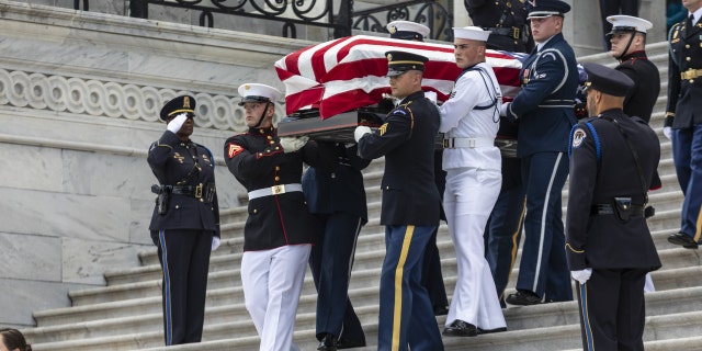 An honor guard carries the casket of Woody Williams down the U.S. Capitol steps after he lied in honor in Washington, D.C., on July 14, 2022.