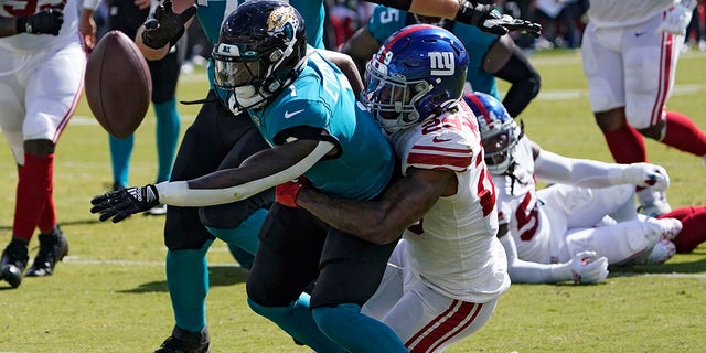 On Sunday, October 23, 2022, Jacksonville Jaguars running back Travis Etienne Jr. (#1) beats New York Giants safety Xavier McKinney (#1) during the first half of an NFL football game in Jacksonville, Florida. 29) was attacked by