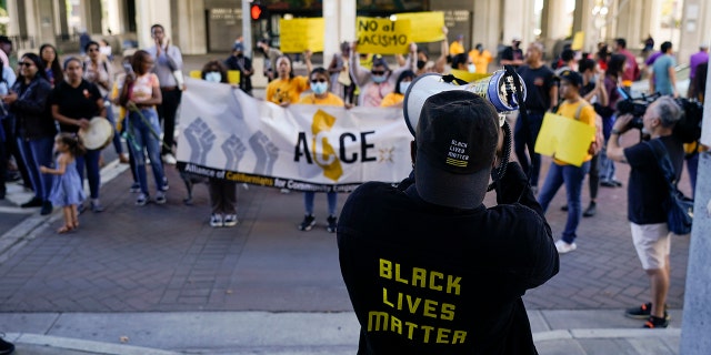 Protesters chant a slogan outside the Los Angeles City Hall in Los Angeles, Tuesday, Oct. 18, 2022. The demonstrators demanded the city council stop its virtual meeting Tuesday until two of its members resign over racist remarks.