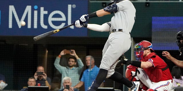 New York Yankees' Aaron Judge hits a solo home run, his 62nd of the season, during the first inning in the second baseball game of a doubleheader against the Texas Rangers in Arlington, Texas, Tuesday, Oct. 4, 2022.