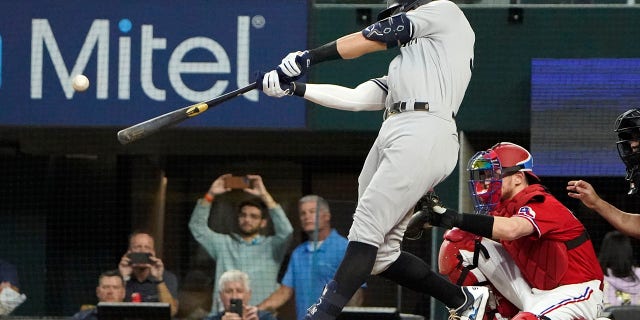 Aaron Judge of the New York Yankees hits a solo home run, his 62nd of the season, during the first inning of the second baseball game of a doubleheader against the Texas Rangers in Arlington, Texas on Tuesday, Oct. 4, 2022. With the home run, Judge set the American League record for home runs in a season, surpassing Roger Maris.