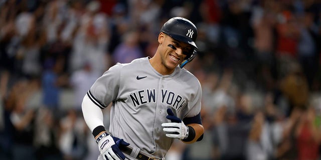 Aaron Judge #99 of the New York Yankees smiles as he rounds the bases after hitting his 62nd home run of the season against the Texas Rangers during the first inning in game two of a double header at Globe Life Field on October 4, 2022 in Arlington, Texas. Judge has now set the American League record for home runs in a single season.