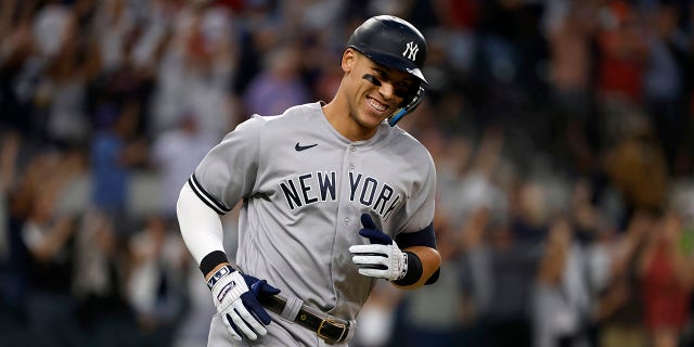 Aaron Judge #99 of the New York Yankees smiles as he rounds the bases after hitting his 62nd home run of the season against the Texas Rangers during the first inning in game two of a double header at Globe Life Field on October 4, 2022 in Arlington, Texas. Judge has now set the American League record for home runs in a single season.