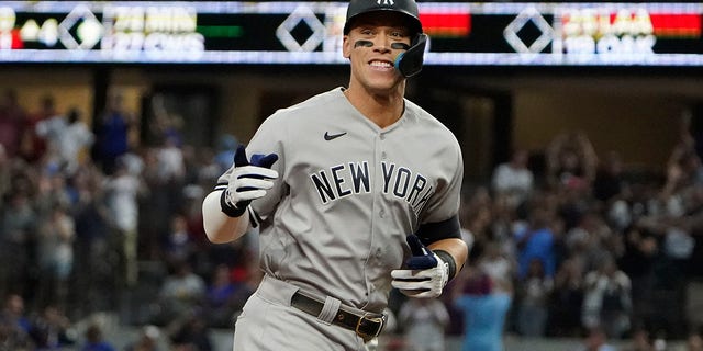 The New York Yankees' Aaron Judge gestures as he rounds the bases after hitting a solo home run, his 62nd of the season, during the first inning in the second game of a doubleheader against the Texas Rangers in Arlington, Texas, Tuesday, Oct. 4, 2022. 