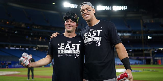 Aaron Judge, right, and Scott Effross of the New York Yankees celebrate becoming the 2022 AL East Division Champions after defeating the Toronto Blue Jays at Rogers Centre on Sept. 27, 2022, in Toronto.
