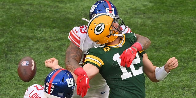 Aaron Rodgers of the Green Bay Packers is sacked by Oshane Ximines of the New York Giants and fumbles the ball during the fourth quarter at Tottenham Hotspur Stadium on Oct. 9, 2022, in London.