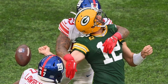 Aaron Rodgers of the Green Bay Packers is sacked by Oshane Ximines of the New York Giants and fumbles the ball during the fourth quarter at Tottenham Hotspur Stadium on Oct. 9, 2022, in London.