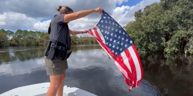 A Volusia County, Fla. deputy rescues an American flag from the St. Johns River following Hurricane Ian.