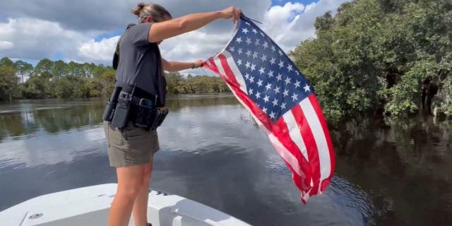 A Volusia County, Fla. deputy rescues an American flag from the St. Johns River following Hurricane Ian.