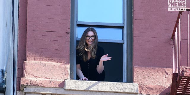 Newly released Anna Sorokin waves from New York City window on Sunday, Oct. 10, 2022