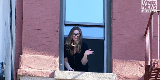 Newly released Anna Sorokin waves from New York City window on Sunday, Oct. 10, 2022
