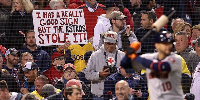 A sign referring to the Astros' cheating scandal is held by a fan during the Red Sox game against Houston during the American League Championship Series at Fenway Park on Oct. 18, 2021, in Boston.
