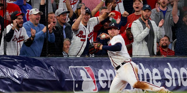 Austin Riley nr 27 z Atlanta Braves łapie i rzuca piłkę podczas ósmej rundy przeciwko Philadelphia Phillies w drugim meczu National League Division Series na Truist Park, 12 października 2022 r. w Atlancie w stanie Georgia.