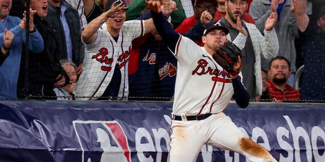 Austin Riley nr 27 z Atlanta Braves łapie i rzuca piłkę podczas ósmej rundy przeciwko Philadelphia Phillies w drugim meczu National League Division Series na Truist Park, 12 października 2022 r. w Atlancie w stanie Georgia.