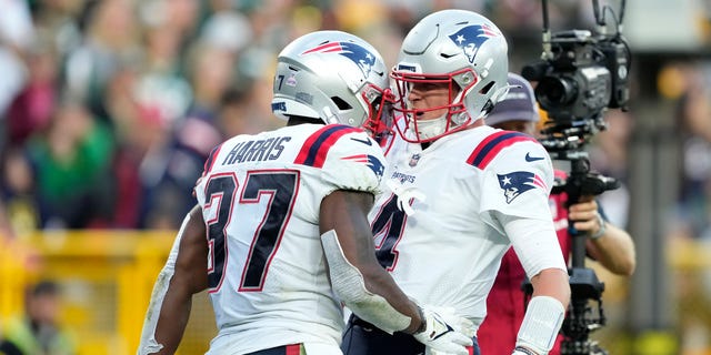 Damien Harris and Bailey Zappe of the New England Patriots celebrate after Harris' touchdown during the fourth quarter against the Green Bay Packers at Lambeau Field on Oct. 2, 2022, in Green Bay, Wisconsin.