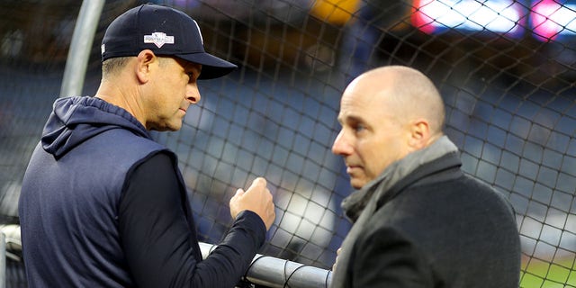 Manager Aaron Boone of the New York Yankees, left, watches batting practice as general manager Brian Cashman looks on prior to Game 4 of the ALCS against the Houston Astros at Yankee Stadium on Oct. 17, 2019, in New York.