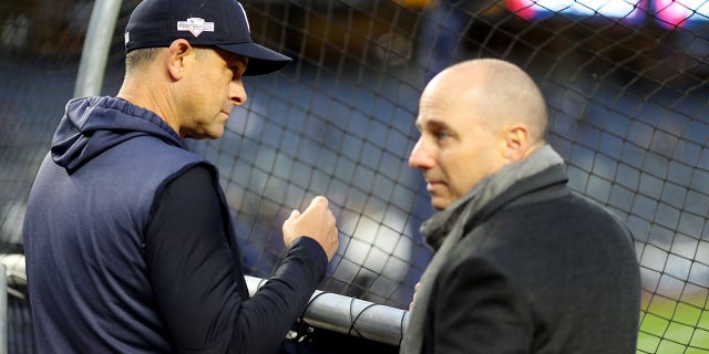 New York Yankees manager Aaron Boone watches batting practice as general manager Brian Cashman looks on prior to Game 4 of the ALCS against the Houston Astros at Yankee Stadium in New York City on Oct. 17, 2019.