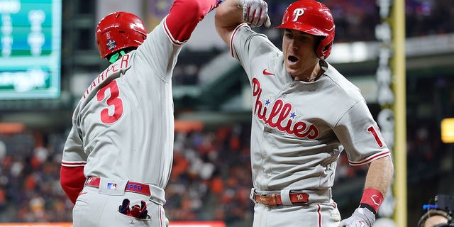 Bryce Harper #3 and J.T. Realmuto #10 of the Philadelphia Phillies celebrate after Realmuto hit a home run in the 10th inning against the Houston Astros in Game One of the 2022 World Series at Minute Maid Park on October 28, 2022 in Houston, Texas. 