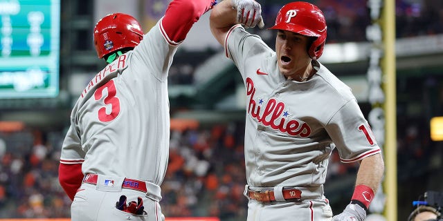 Bryce Harper #3 and J.T. Realmuto #10 of the Philadelphia Phillies celebrate after Realmuto hit a home run in the 10th inning against the Houston Astros in Game One of the 2022 World Series at Minute Maid Park on October 28, 2022 in Houston, Texas.