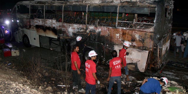 A bus fire in Nooriabad, Pakistan, killed over a dozen flood survivors, including children and women, on Oct. 13, 2022. Pictured: Volunteers arrive at the scene of the fire.