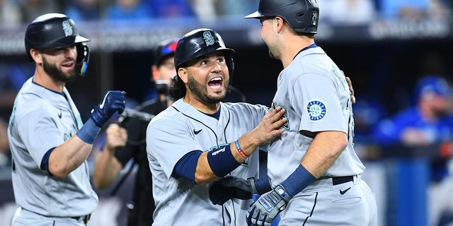 Seattle Mariners catcher Cal Raleigh, right, celebrates his home run with infielder Eugenio Suarez during the first inning of wild-card Game 1 against the Toronto Blue Jays Oct. 7, 2022, in Toronto.